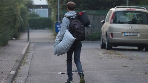 Ein Anwohner verlässt die Evakuierungszone mit einem Kissen unter dem Arm. 