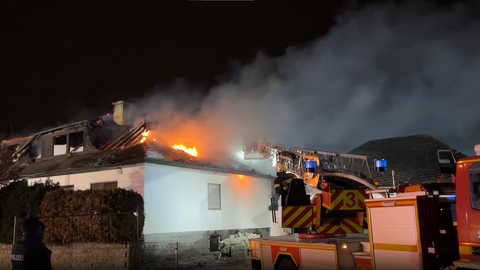 Feuerwehrauto vor brennendem Haus