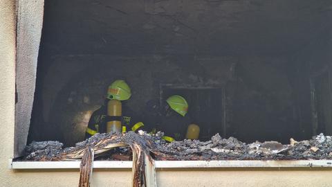 Zwei Feuerwehrleute in einer ausgebrannten Wohnung in Frankfurt-Bockenheim.