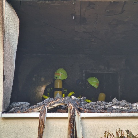 Zwei Feuerwehrleute in einer ausgebrannten Wohnung in Frankfurt-Bockenheim.