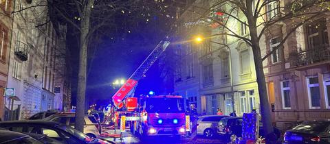 Ein Feuerwehrauto steht in einer Straße in der Dunkelheit und hat einen Einsatz.