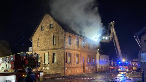 Feuerwehr nachts bei Löscharbeiten an Haus