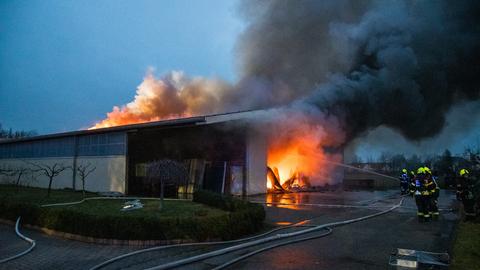 Flammen und Rauch über einer brennenden Halle in Groß-Zimmern