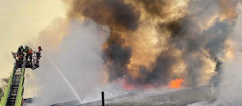 Die Feuerwehr bei den Löscharbeiten an der brennenden Halle