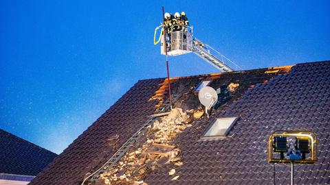 Feuerwehrleute löschen einen Dachstuhlbrand.