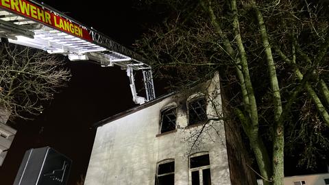 Ein ausgebranntes Haus, daneben eine Drehleiter der Feuerwehr.