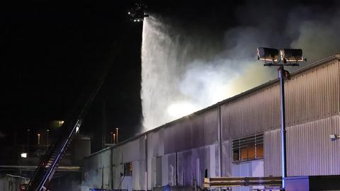 Ein Dach einer Blechhalle - von oben regnet es aus einem Feuerwehrschlauch.