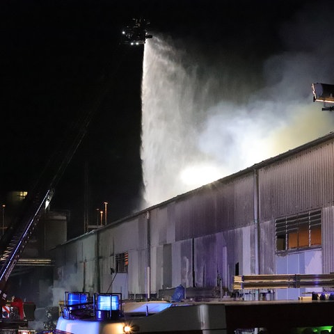 Ein Dach einer Blechhalle - von oben regnet es aus einem Feuerwehrschlauch.