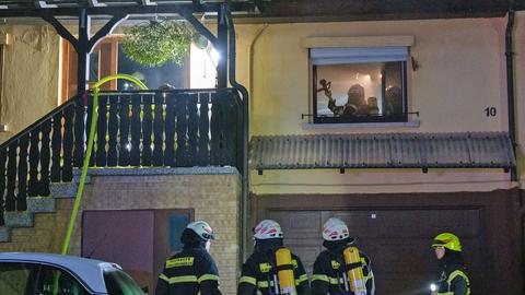 Feuerwehrleute an Haus aus dem Rauch dringt