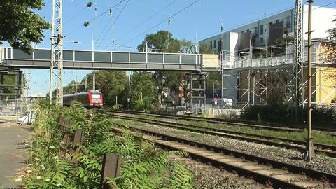 Brücke über Schienen, auf denen Zug fährt