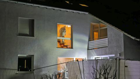 Ein Mitarbeiter der Spurensicherung im Treppenhaus eines Hauses, von außen fotografiert