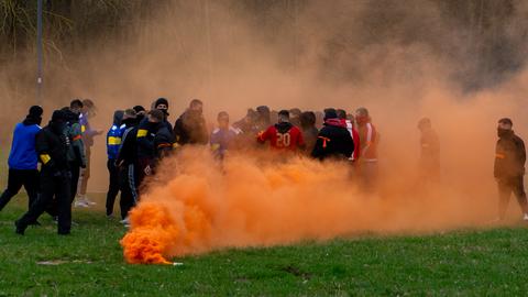 Pyrotechnik gezündet: gewaltbereite Fangruppen stehen auf dem Rasen.