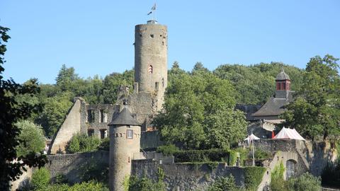 Die alte Burg liegt oberhalb der gleichnamigen Stadt Eppstein. Auf dem Burgturm wehen zwei Fahnen im Wind.
