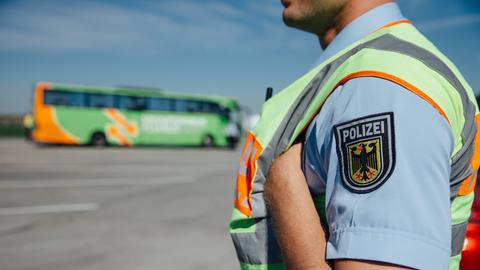 Ein Polizist, im Hintergrund ein Reisebus.