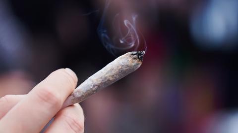 Eine Person zieht an einem Cannabis-Joint. 
