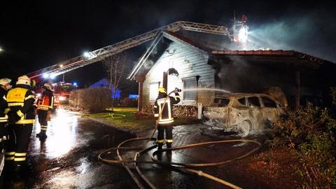 Feuerwehr löscht Auto unter Carport.