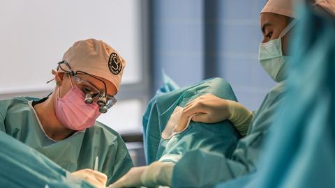 Eine Chirurgin führt in einem OP-Saal eine Operation im Intimbereich durch.