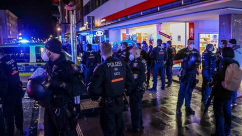 Eine große Gruppe von Einsatzkräften der Polizei steht auf einer innerstädtischen Straße.