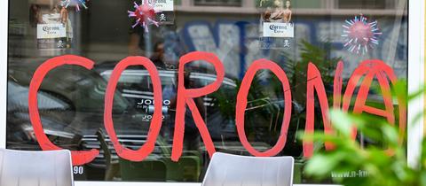 Das Schaufenster eines Friseurgeschäfts " auf der Berger Straße in Frankfurt ist mit dem Wort "Corona" bemalt. 
