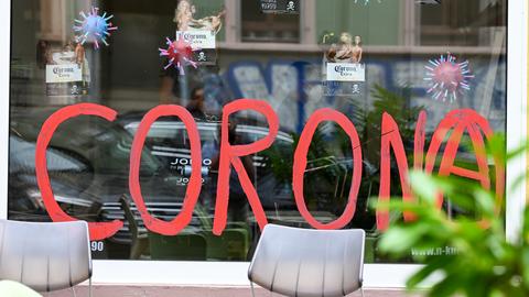 Das Schaufenster eines Friseurgeschäfts " auf der Berger Straße in Frankfurt ist mit dem Wort "Corona" bemalt. 