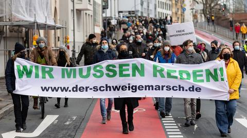 Teilnehmer einer Demonstration gegen Corona-Maßnahmen tragen in der Frankfurter Innenstadt ein Banner mit der Aufschrift "Wir müssen Reden".