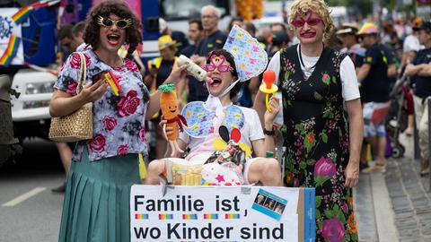 CSD-Teilnehmende - als Mutter - Mutter - Kind verkleidet - am Kinderwagen die Aufschrift: "Familie ist, wo Kinder sind."