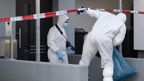Zwei Beamte der Spurensicherung vor einem Wohnhaus in Darmstadt-Arheiligen