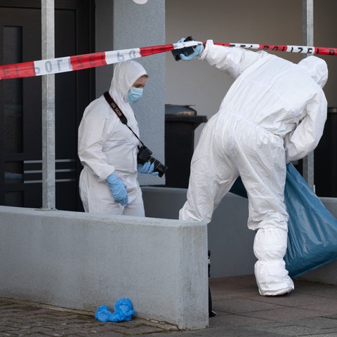 Zwei Beamte der Spurensicherung vor einem Wohnhaus in Darmstadt-Arheiligen