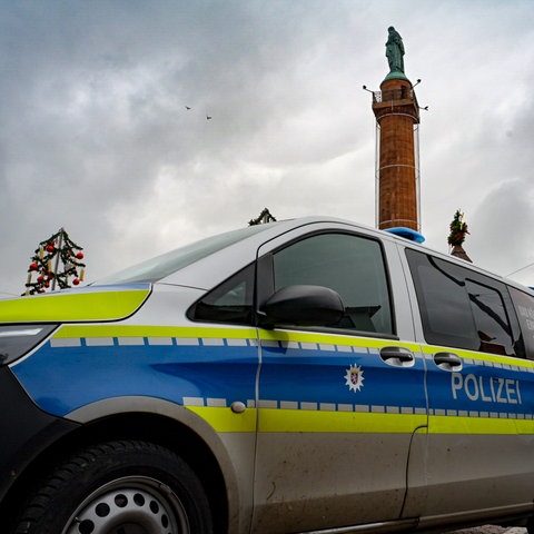Auf dem Darmstädter Luisenplatz steht nach einer Attacke auf einen Obdachlosen ein Polizeiauto. Im Hintergrund ist das Ludwigsmonument zu sehen.