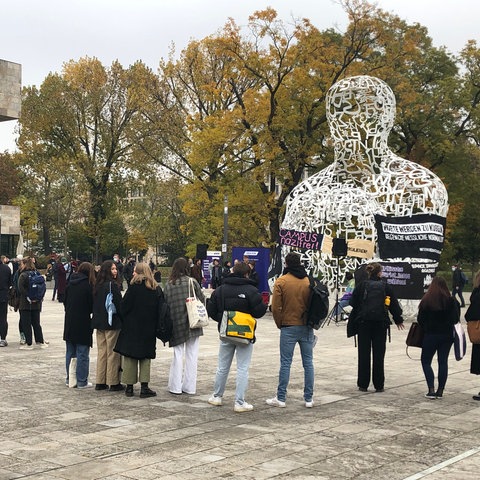 Menschen stehen, Plakat "Campus Nazifrei" zu lesen