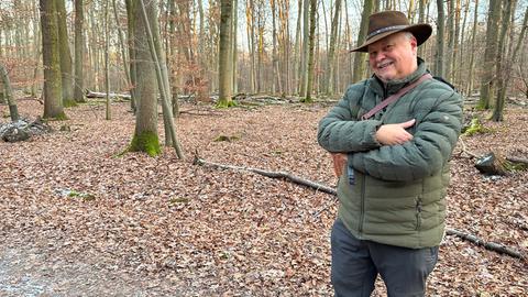 Ein Mann Mitte 50 steht im winterlichen Frankfurter Stadtwald 