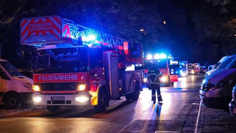 Mehrere Feuerwehrautos bei Nacht in einer Wohnstraße.