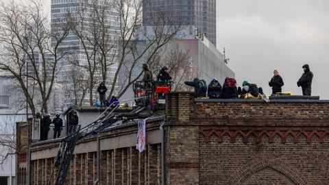 Polizisten des SEK stehen auf einer Drehleiter am Dach der Dondorf-Druckerei.