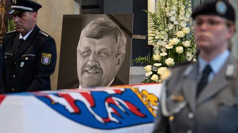 Beerdigung von Walter Lübcke. Ein Portrait von ihm steht neben Sarg, Kerzen und einem Polizisten.