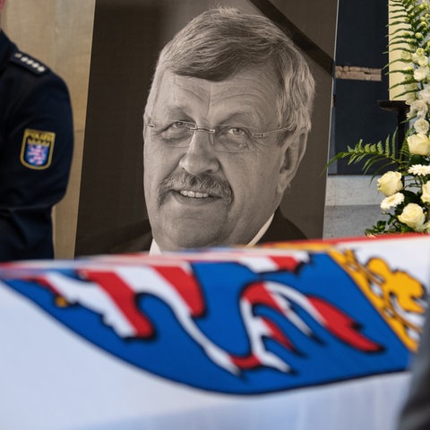 Beerdigung von Walter Lübcke. Ein Portrait von ihm steht neben Sarg, Kerzen und einem Polizisten.
