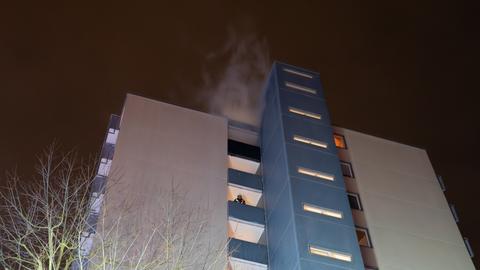 Qualmendes Hochhaus und Feuerwehrleute