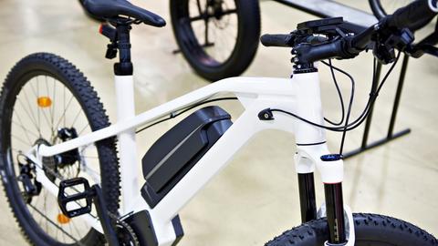 Rahmen eines weißen E-Bikes, im Hintergrund ist ein Raum zu erkennen (Symbolbild)