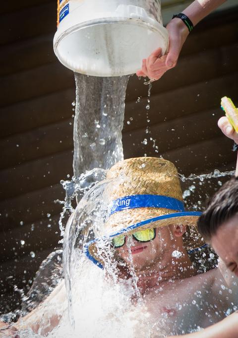 Junge bekommt Eimer Wasser über den Kopf