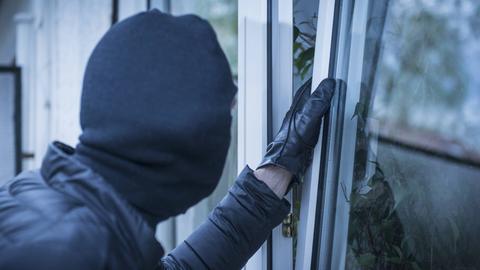 Einbrecher öffnet Fenster