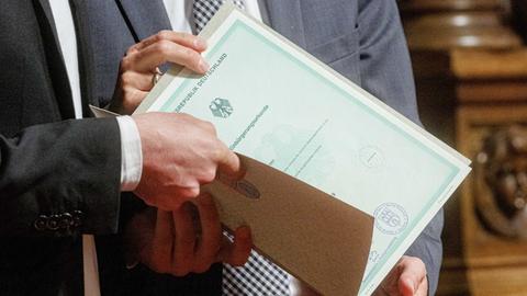 Mensch hält Einbürgerungsurkunde
