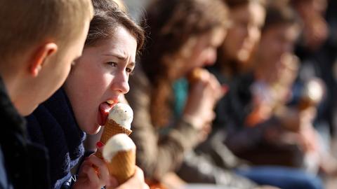 Noch warm angezogen essen die ersten Spaziergänger wieder Eis.