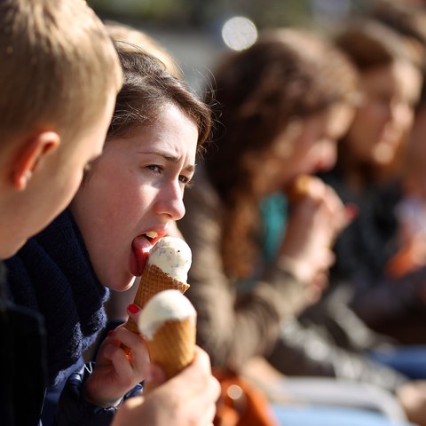 Noch warm angezogen essen die ersten Spaziergänger wieder Eis.