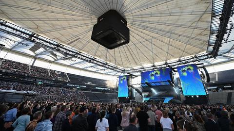 Im Frankfurter Stadion schauen tausende Menschen auf eine Bühne, die auf dem Rasen aufgebaut ist.