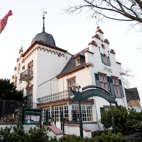 Historisches Gebäude von außen fotografiert. Neben dem Eingang steht eine Fahne.