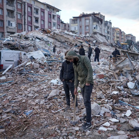 Civilians try to search the rubble for earthquake survivors. 