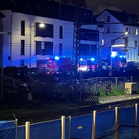 Rettungskräfte stehen am Bahnhof Frankfurt-Eschersheim. 