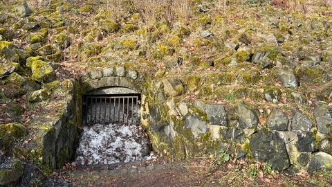 Hügel mit Steinen und Gras, Metallgitter, Eis vermengt mit Steinen tritt hervor