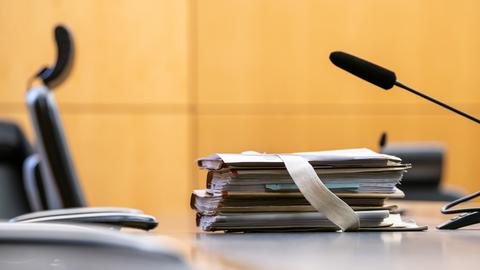 Akten liegen auf einem Tisch in einem Gerichtssaal des Landgerichts Darmstadt