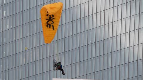 Mit einem Gleitschirm landet ein Greenpeace-Aktivist auf dem Dach der Europäischen Zentralbank (EZB).