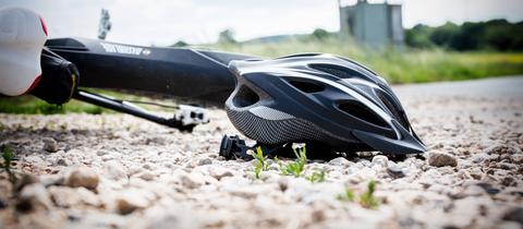 Symbolbild: Ein Fahrrad liegt nach einem Sturz samt Helm auf dem Boden.